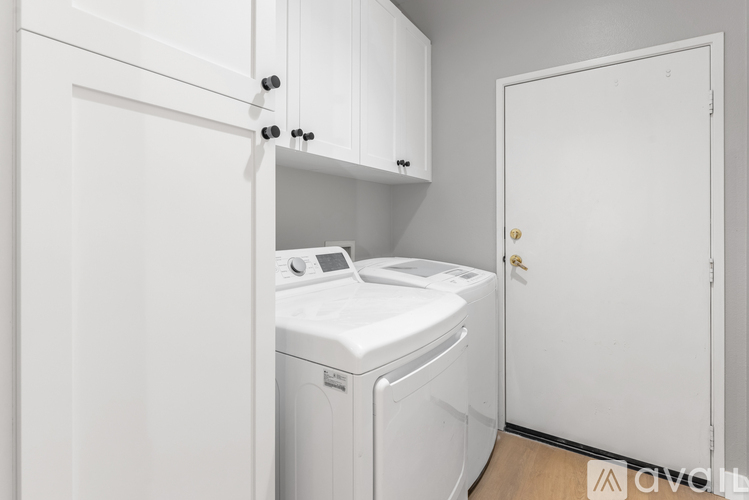 A white washing machine sits in a small laundry room.