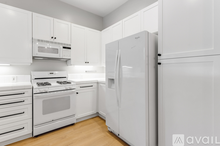 A kitchen with white cabinets and appliances.