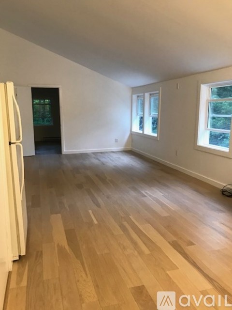 A room with wooden flooring and white walls.