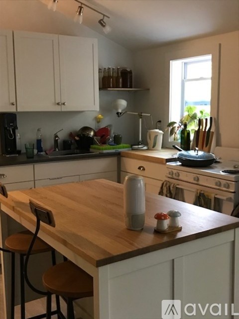 A kitchen with a wooden table and white cabinets.