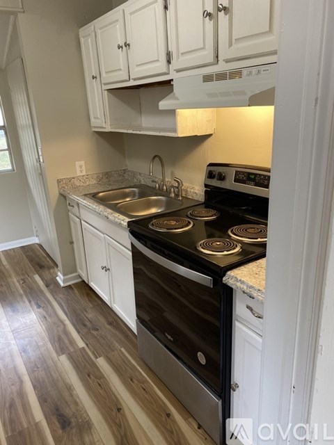 A kitchen with a stove top oven and a sink.