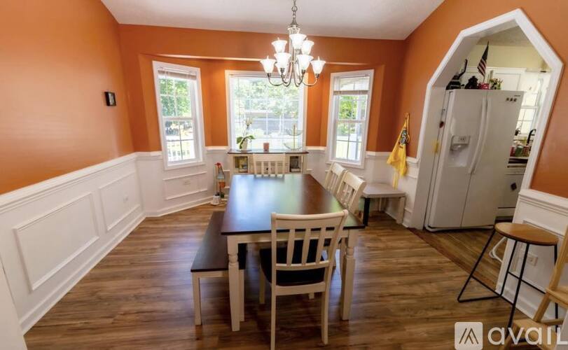 A dining room with a wooden table and chairs.