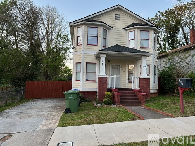 A two-story house with a red front door and white trim.