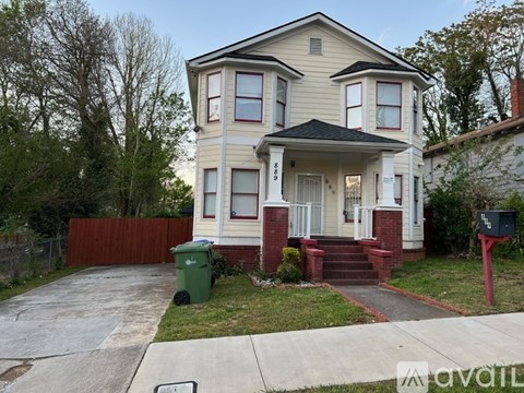 A two-story house with a red front door and white trim.