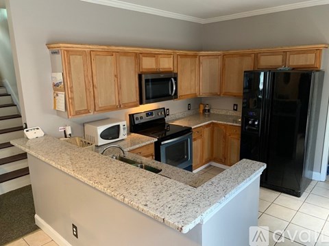 A kitchen with wooden cabinets and granite countertops.