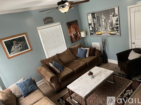 A living room with a brown couch and a coffee table.