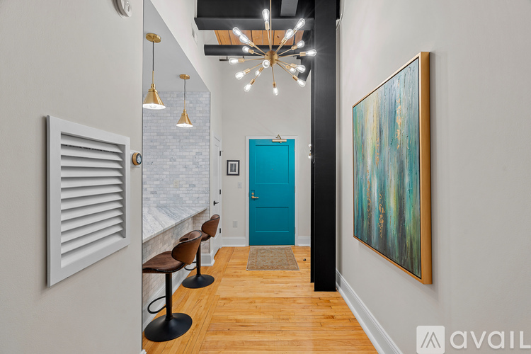 A hallway with a blue door and a painting on the wall.