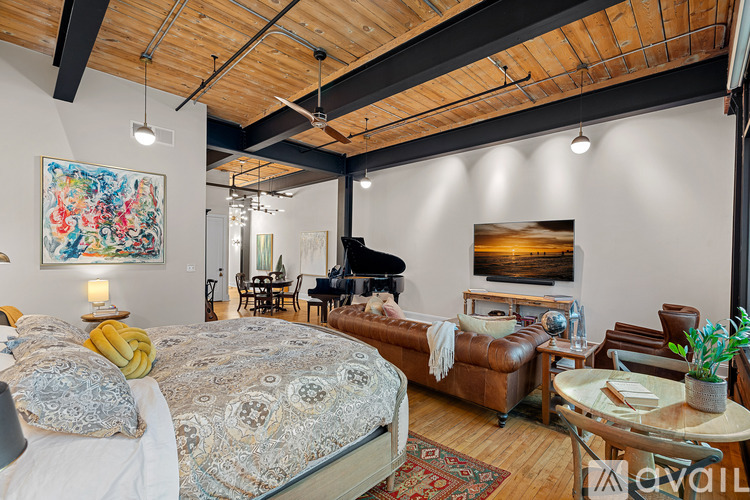 A bedroom with a large bed and a painting on the wall.