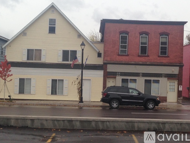A black SUV is parked in front of a red brick building.