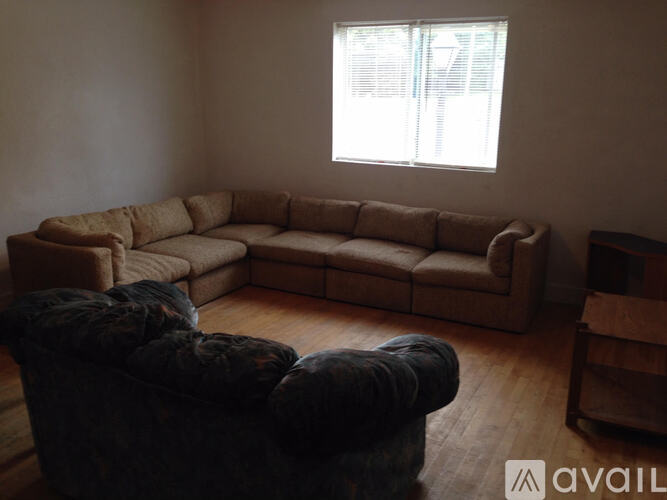 A living room with a large sectional sofa and a darker sofa in front of a window.