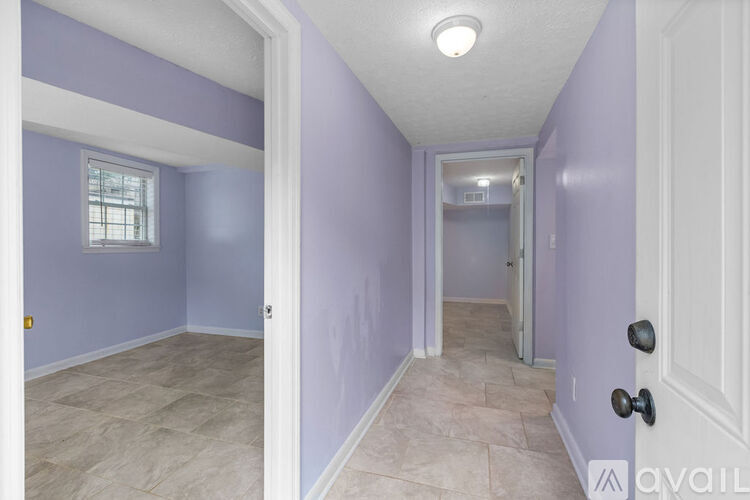 A hallway with purple walls and a white door.