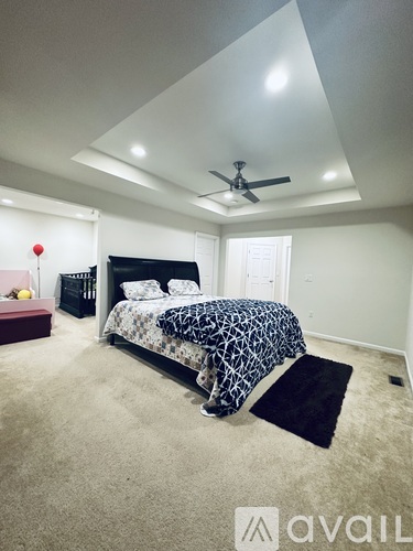 A bedroom with a bed, nightstand, and ceiling fan.