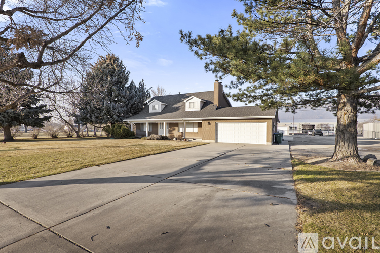 A house with a driveway and trees in front.