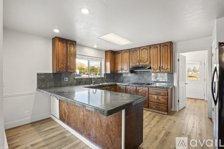 A kitchen with wooden cabinets and a black countertop.