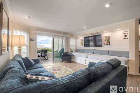 A living room with a grey sofa and a large window.