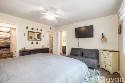A bedroom with a large bed and a flat screen TV mounted on the wall.