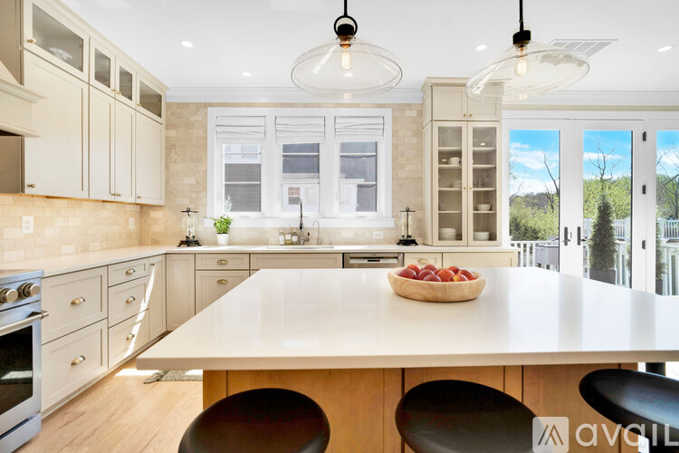A kitchen with a table and chairs and a bowl of fruit on the table.