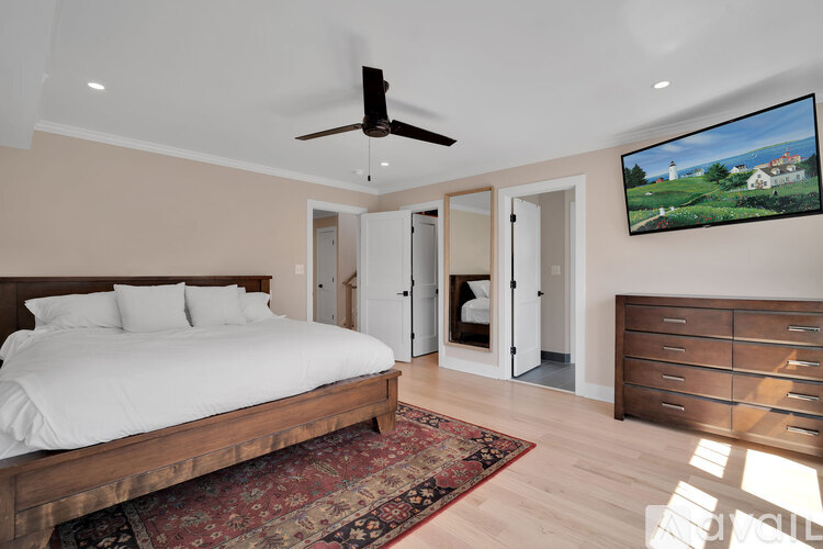 A bedroom with a large bed and a flat screen TV mounted on the wall.