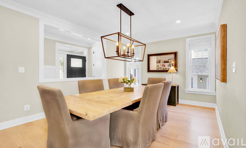 A modern dining room with a wooden table and chairs.