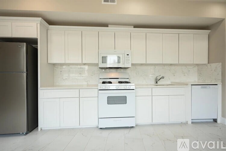 A kitchen with white cabinets and appliances.