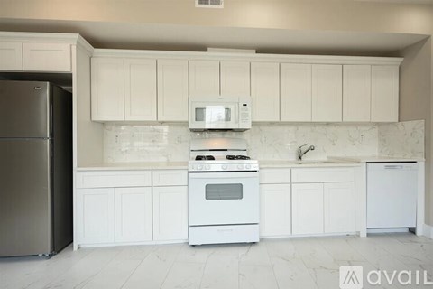 A kitchen with white cabinets and appliances.