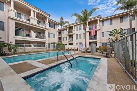A swimming pool in front of a building with a flag on it.