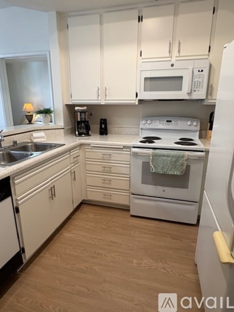 A kitchen with white cabinets and appliances.