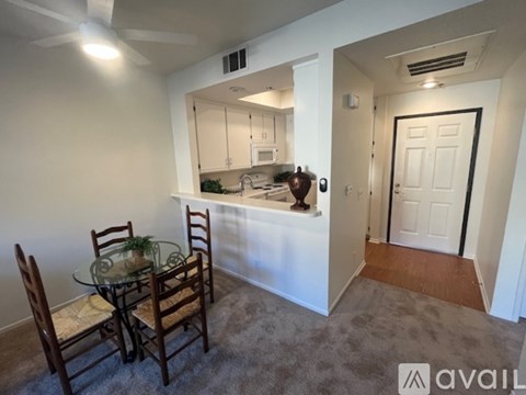 A dining area with a glass table and chairs.