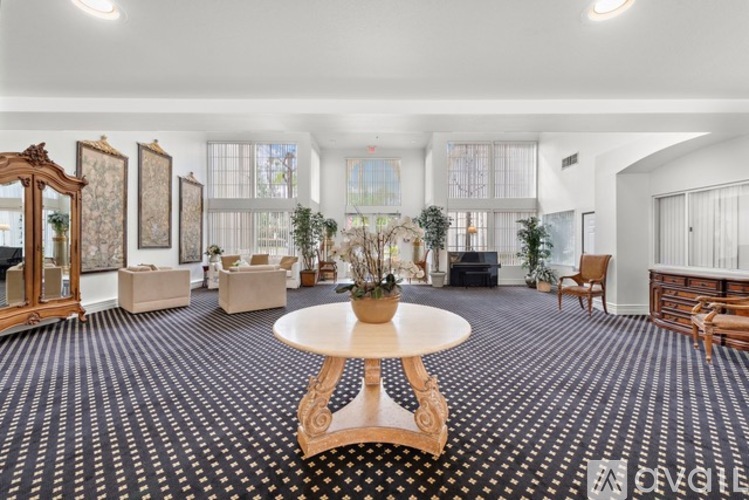 A living room with a wooden floor and a round table in the middle.