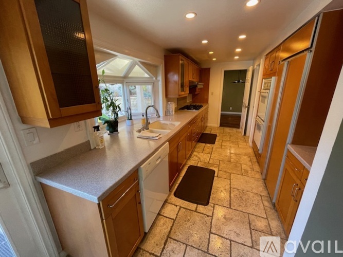 A kitchen with wooden cabinets and a tiled floor.