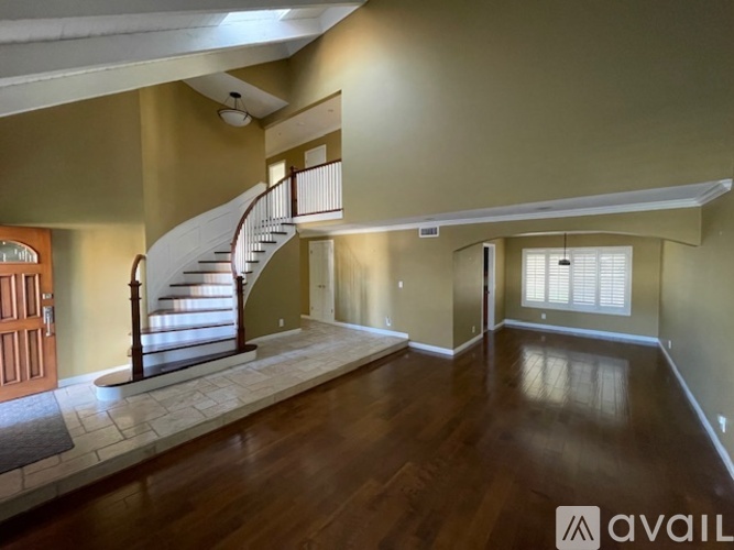 A spacious room with a staircase and a window.