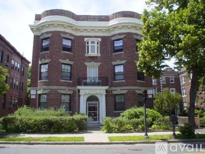 A red brick building with a white trim and a balcony on the second floor.