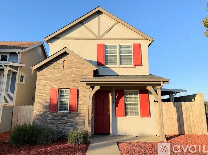 A house with a red door and red shutters is for sale.