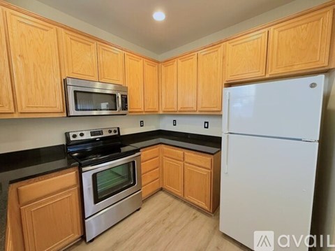 A kitchen with wooden cabinets and a white refrigerator.