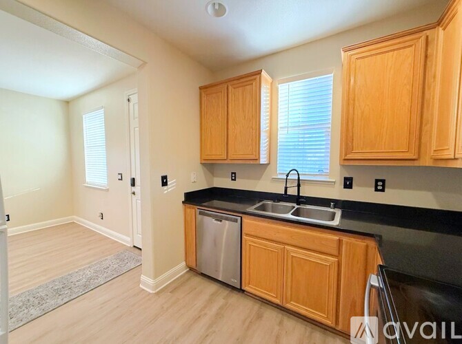 A kitchen with wooden cabinets and a black countertop.