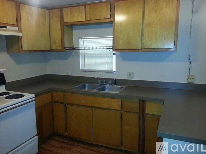 A kitchen with wooden cabinets and a white stove top oven.