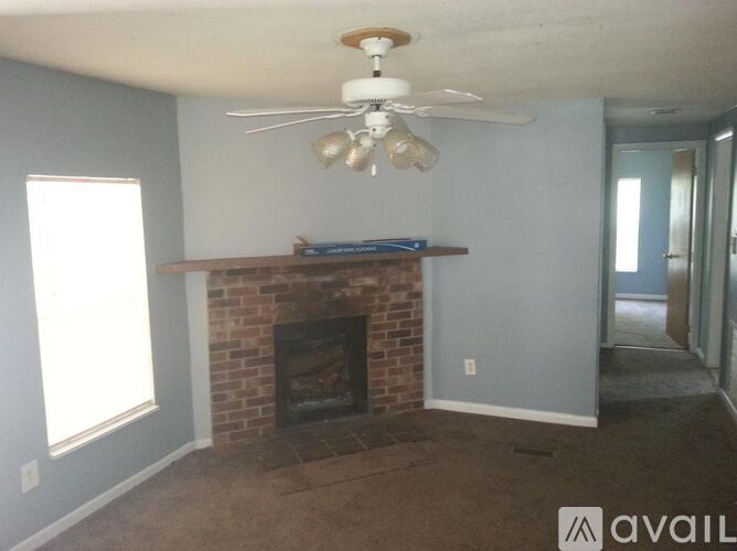 A living room with a fireplace and a ceiling fan.