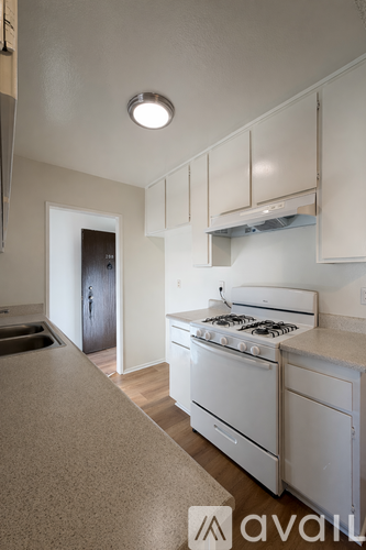 A kitchen with white appliances and cabinets.