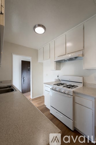 A kitchen with white appliances and cabinets.