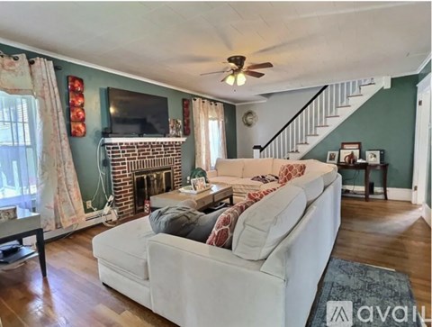 A living room with a white couch and a fireplace.