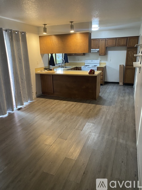 A kitchen with wooden floors and a countertop with a lamp on it.