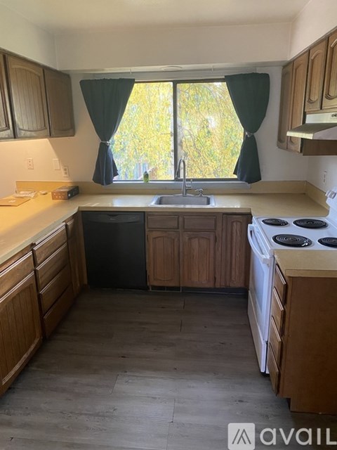 A kitchen with wooden cabinets and a stove top oven.