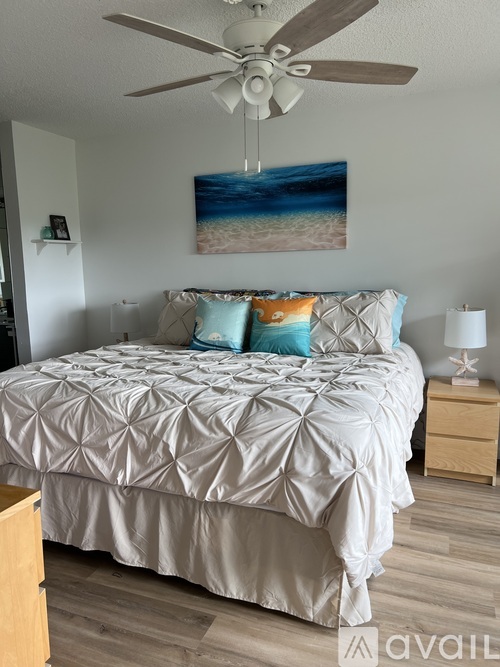 A bedroom with a large bed and a ceiling fan.