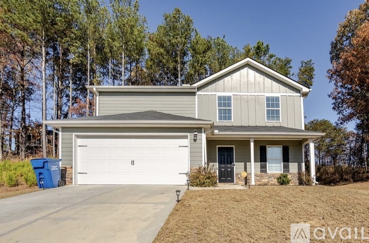 A house with a garage and a driveway in front of it.