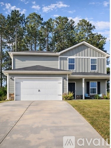 A house with a garage and a driveway in front of it.