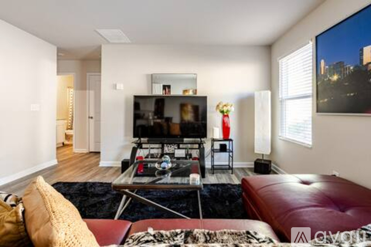 A living room with a red couch and a black coffee table.