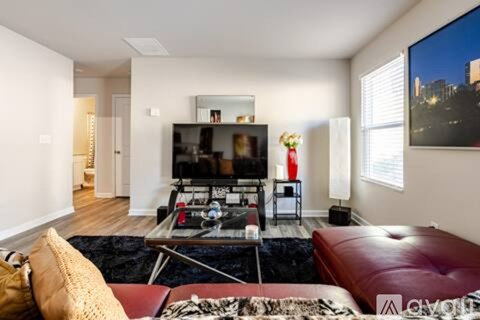 A living room with a red couch and a black coffee table.