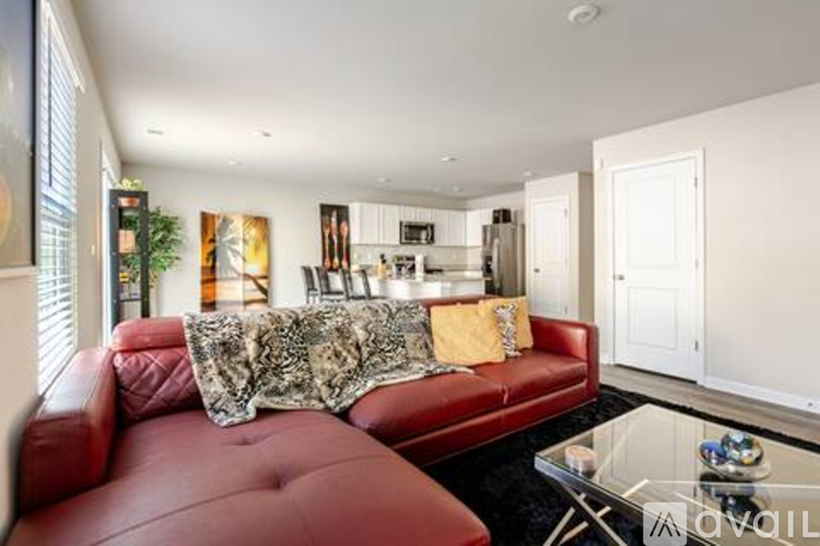 A red couch with a patterned throw sits in a modern living room.