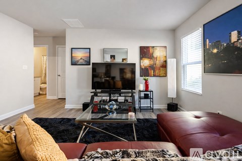 A kitchen with white cabinets and a black refrigerator.