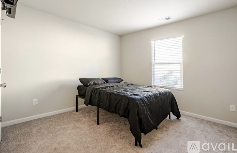 A bedroom with a bed and a window.